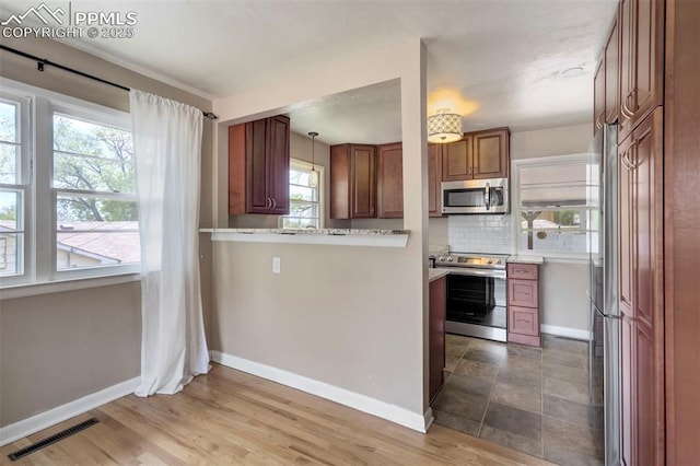 717 W Monroe St, Colorado Springs, CO 80907 - kitchen featuring stainless steel appliances, baseboards, backsplash, light countertops, and brown cabinetry