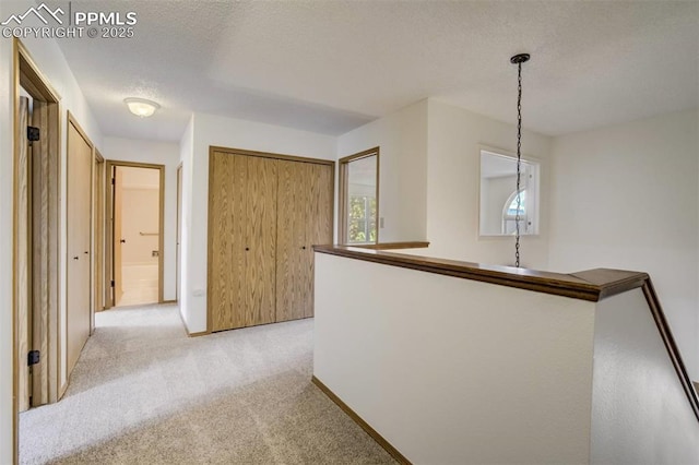 1559 Sausalito Dr, Colorado Springs, CO 80907 - hallway with light carpet, a textured ceiling, and baseboards