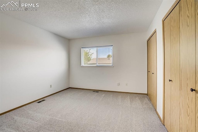1559 Sausalito Dr, Colorado Springs, CO 80907 - unfurnished bedroom featuring light colored carpet, a textured ceiling, and baseboards