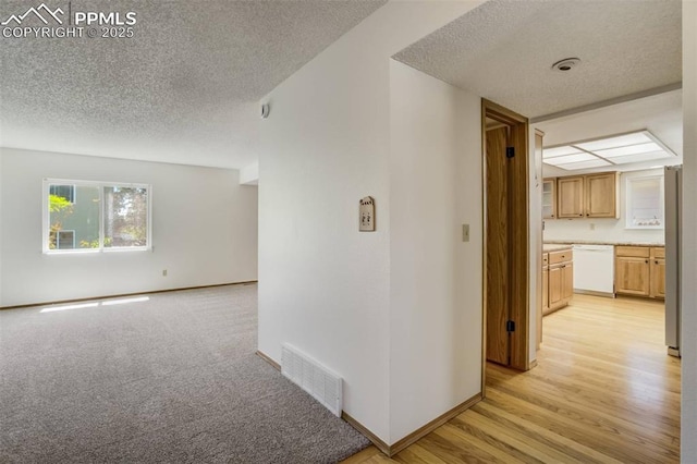 1559 Sausalito Dr, Colorado Springs, CO 80907 - hallway featuring a textured ceiling, baseboards, and light wood-style floors
