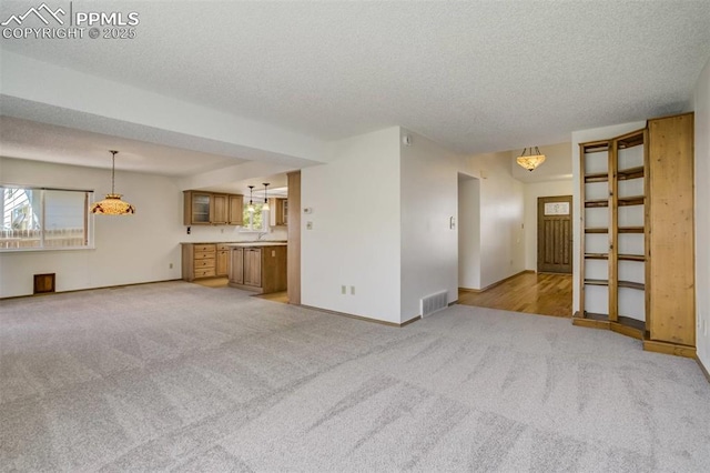 1559 Sausalito Dr, Colorado Springs, CO 80907 - unfurnished living room with light colored carpet, a textured ceiling, and baseboards