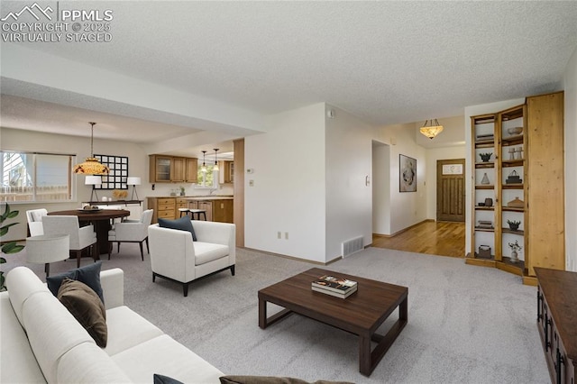 1559 Sausalito Dr, Colorado Springs, CO 80907 - living room featuring light colored carpet, a textured ceiling, and baseboards