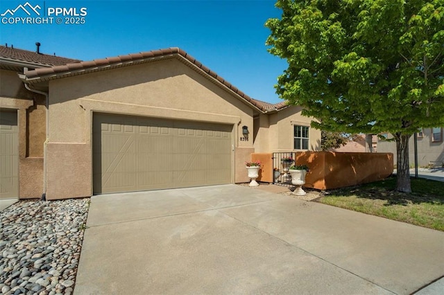 8396 Snow Cap Vw, Colorado Springs, CO 80920 - view of front of home with a garage, stucco siding, concrete driveway, and a tiled roof