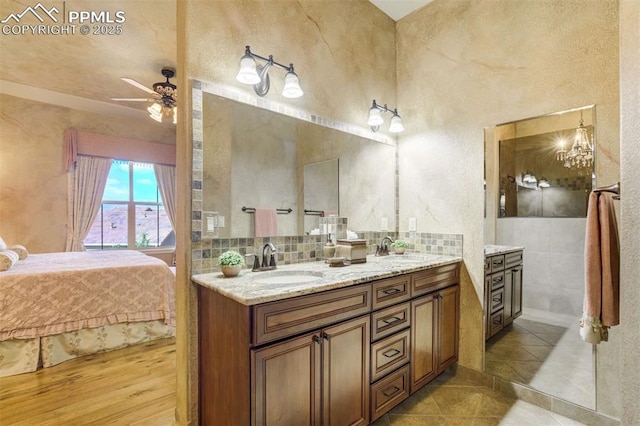 8396 Snow Cap Vw, Colorado Springs, CO 80920 - full bathroom featuring double vanity, a ceiling fan, connected bathroom, backsplash, and tile patterned floors