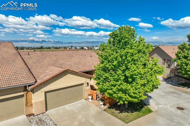 8396 Snow Cap Vw, Colorado Springs, CO 80920 - view of front facade featuring a tiled roof, stucco siding, an attached garage, and concrete driveway