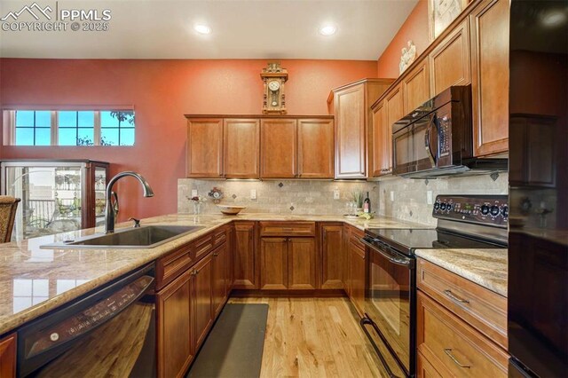 8396 Snow Cap Vw, Colorado Springs, CO 80920 - kitchen featuring black appliances, a sink, brown cabinetry, light wood-style flooring, and decorative backsplash