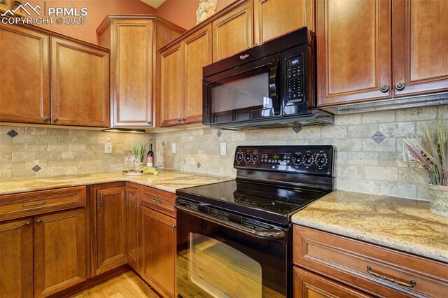 8396 Snow Cap Vw, Colorado Springs, CO 80920 - kitchen with black appliances, light stone countertops, brown cabinetry, and backsplash