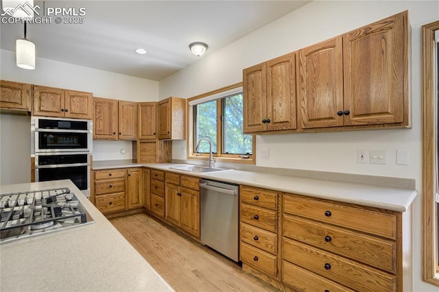 15635 Kingswood Dr, Colorado Springs, CO 80921 - kitchen featuring stainless steel appliances, light wood-style flooring, light countertops, and hanging light fixtures