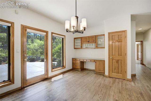 15635 Kingswood Dr, Colorado Springs, CO 80921 - unfurnished dining area featuring light wood-style floors, built in desk, and a chandelier