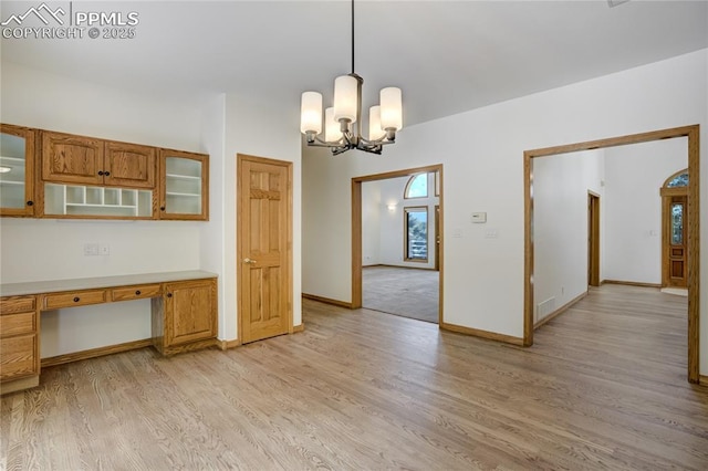 15635 Kingswood Dr, Colorado Springs, CO 80921 - unfurnished dining area with light wood-style flooring, built in study area, and a chandelier