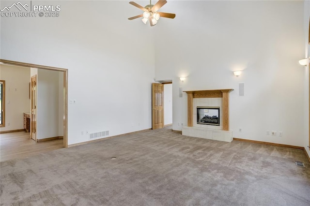 15635 Kingswood Dr, Colorado Springs, CO 80921 - unfurnished living room featuring a high ceiling, a ceiling fan, carpet flooring, and a tiled fireplace