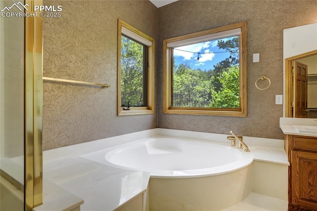 15635 Kingswood Dr, Colorado Springs, CO 80921 - bathroom featuring plenty of natural light, wallpapered walls, vanity, and a garden tub