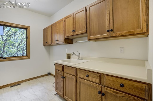 15635 Kingswood Dr, Colorado Springs, CO 80921 - kitchen featuring brown cabinetry, light countertops, and light marble finish floors