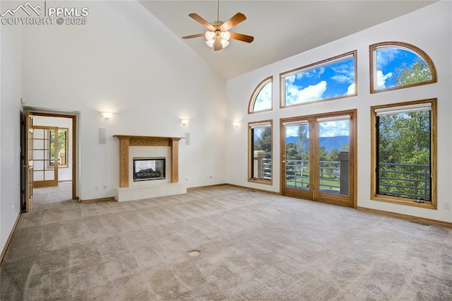 15635 Kingswood Dr, Colorado Springs, CO 80921 - unfurnished living room featuring high vaulted ceiling, a ceiling fan, light carpet, and a tile fireplace