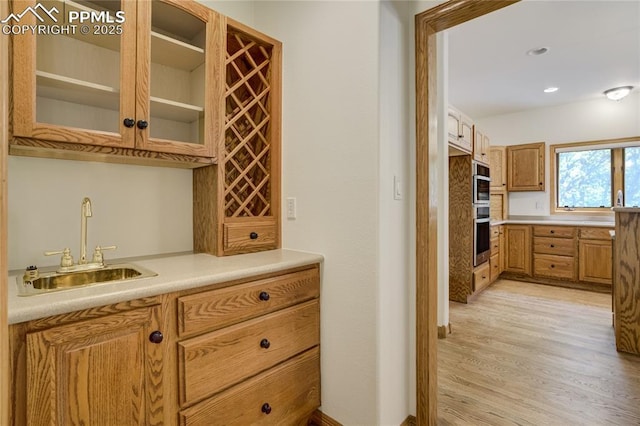15635 Kingswood Dr, Colorado Springs, CO 80921 - indoor wet bar with light wood-style flooring and stainless steel double oven