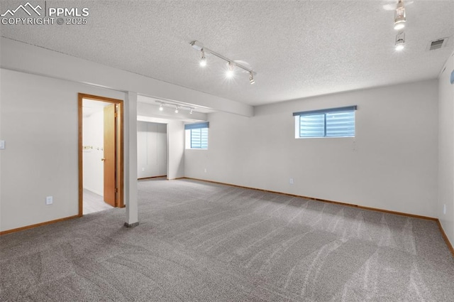 870 N Grey Eagle Cir, Colorado Springs, CO 80919 - below grade area with track lighting, carpet floors, baseboards, and a textured ceiling