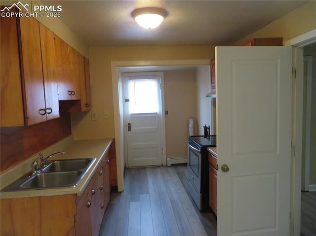 2354 E San Rafael St, Colorado Springs, CO 80909 - kitchen featuring a sink, stainless steel electric stove, light wood-style floors, extractor fan, and a baseboard heating unit