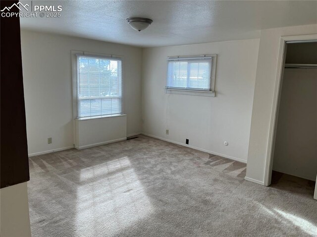 2354 E San Rafael St, Colorado Springs, CO 80909 - unfurnished bedroom featuring carpet flooring, a textured ceiling, and baseboards