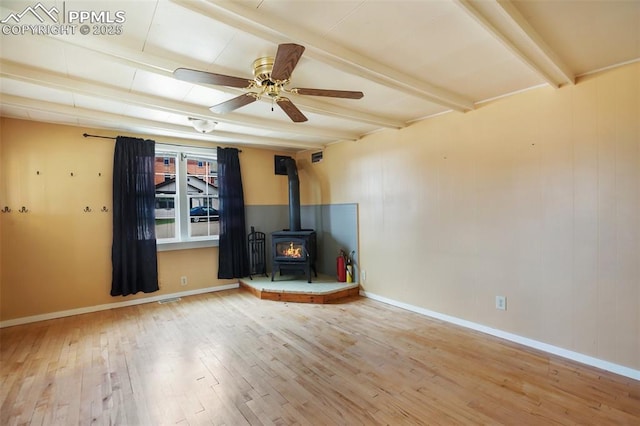 206 N 4th St, Victor, CO 80860 - unfurnished living room with wood finished floors, a wood stove, beamed ceiling, a ceiling fan, and baseboards