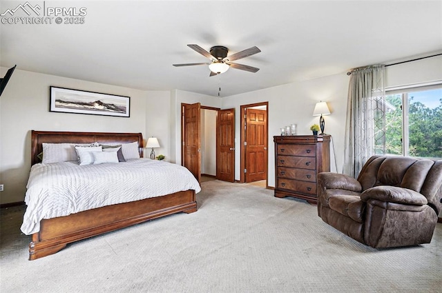 carpeted bedroom with ceiling fan and baseboards