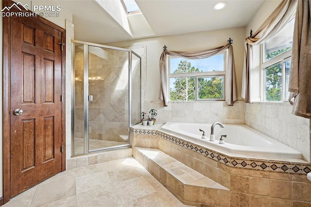 full bathroom featuring a skylight, a shower stall, a garden tub, and recessed lighting