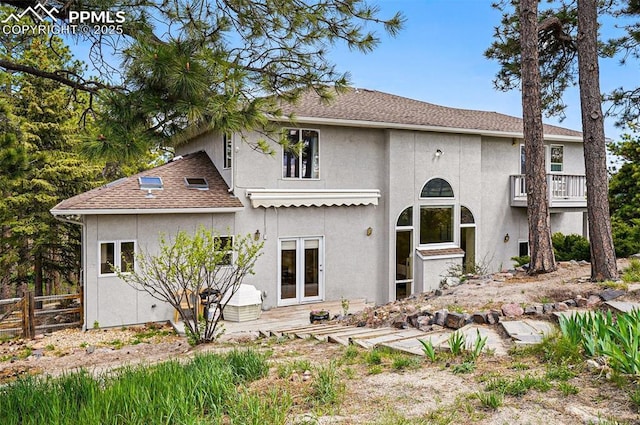 rear view of house with stucco siding, fence, and a patio area