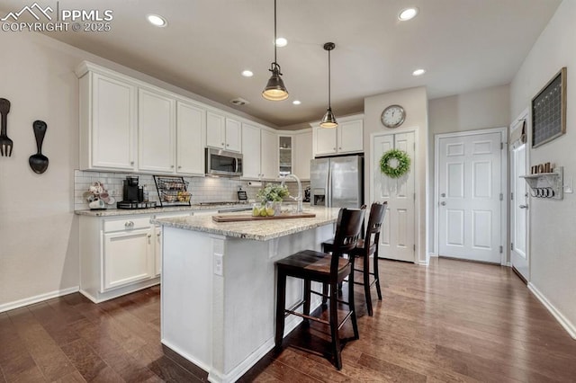 3793 Cadence Dr, Castle Rock, CO 80109 - kitchen with stainless steel appliances, white cabinetry, decorative backsplash, dark wood finished floors, and recessed lighting