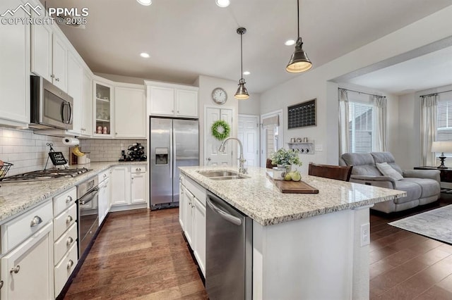 3793 Cadence Dr, Castle Rock, CO 80109 - kitchen with stainless steel appliances, open floor plan, glass insert cabinets, tasteful backsplash, and dark wood finished floors