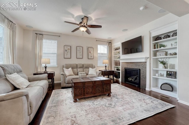 3793 Cadence Dr, Castle Rock, CO 80109 - living area featuring dark wood-style flooring, a ceiling fan, a glass covered fireplace, and healthy amount of natural light