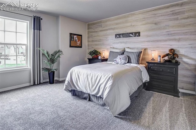 bedroom featuring carpet, baseboards, and an accent wall