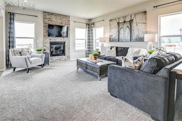 living room featuring carpet, a stone fireplace, and recessed lighting