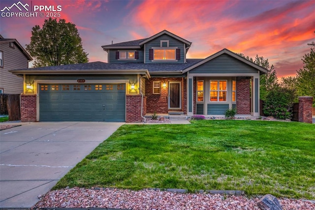 traditional-style home with brick siding, concrete driveway, a garage, and a lawn