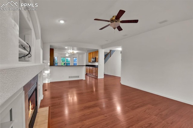 unfurnished living room with a fireplace with flush hearth, a ceiling fan, wood finished floors, baseboards, and recessed lighting