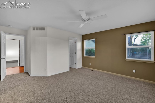 unfurnished bedroom featuring carpet, baseboards, multiple windows, and a ceiling fan