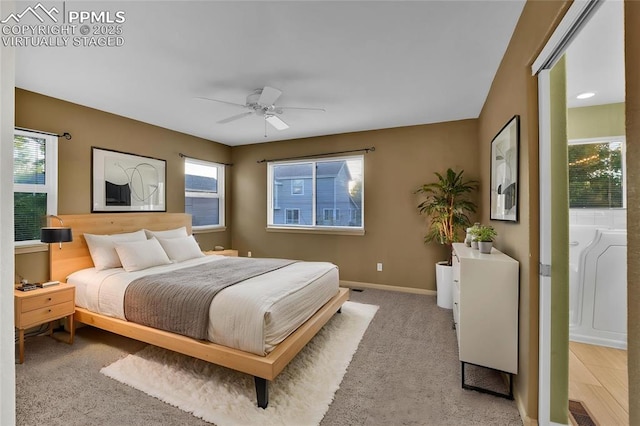 bedroom with light colored carpet, baseboards, and a ceiling fan
