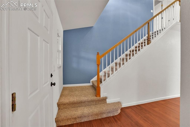 staircase with baseboards and wood finished floors