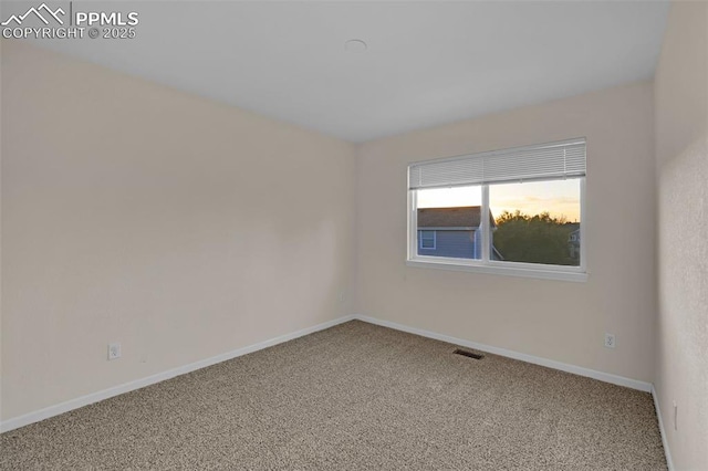 carpeted spare room with baseboards