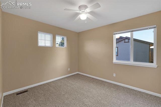 empty room with carpet floors, a ceiling fan, and baseboards