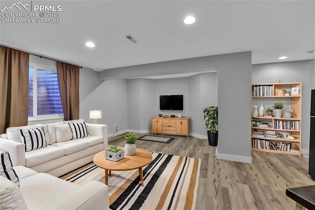 living area with baseboards, light wood-style floors, and recessed lighting