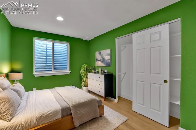 bedroom with wood finished floors, recessed lighting, and a closet