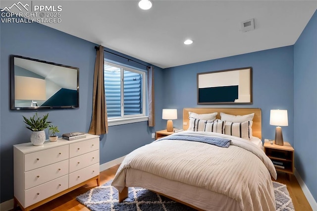 bedroom with baseboards, wood finished floors, and recessed lighting