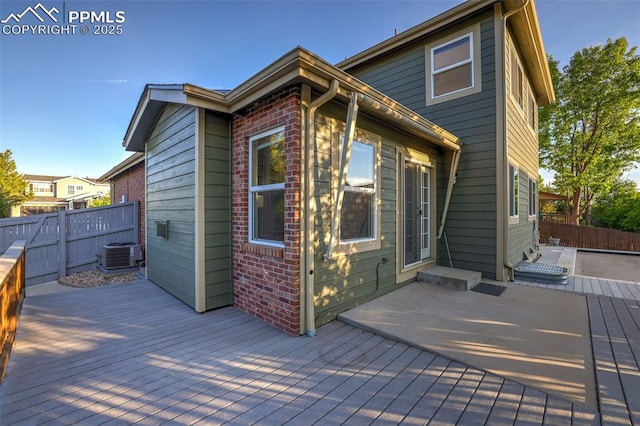 wooden deck featuring fence, central air condition unit, and a patio area