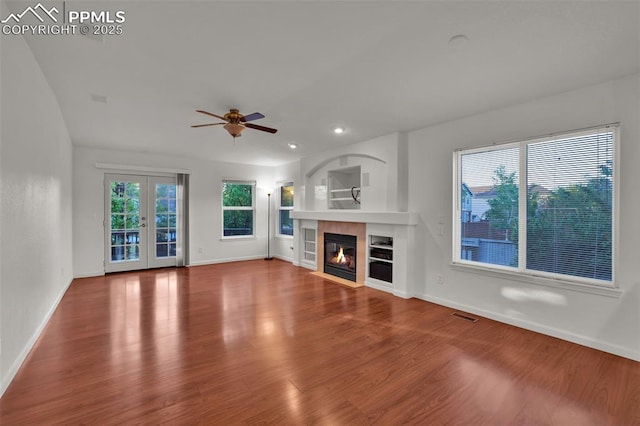 unfurnished living room featuring a ceiling fan, baseboards, wood finished floors, and recessed lighting