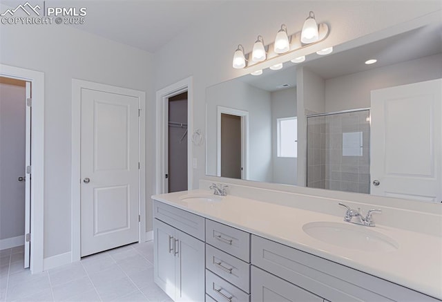 6045 Miller Run Pl, Colorado Springs, CO 80924 - full bathroom with tile patterned flooring, a tile shower, double vanity, baseboards, and a walk in closet