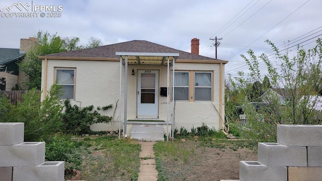 2733 5th Ave, Pueblo, CO 81003 - view of front facade with stucco siding, roof with shingles, and a chimney