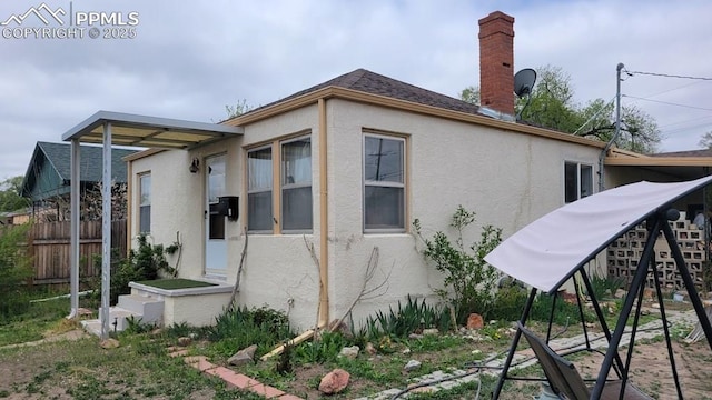 2733 5th Ave, Pueblo, CO 81003 - view of side of property featuring stucco siding, fence, and a chimney