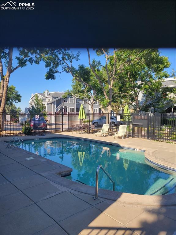 community pool featuring fence and a patio