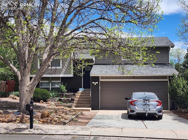 5427 Alteza Dr, Colorado Springs, CO 80917 - view of front of home with driveway, roof with shingles, a garage, and brick siding