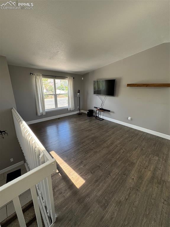 5427 Alteza Dr, Colorado Springs, CO 80917 - unfurnished living room with dark wood finished floors, baseboards, and a textured ceiling