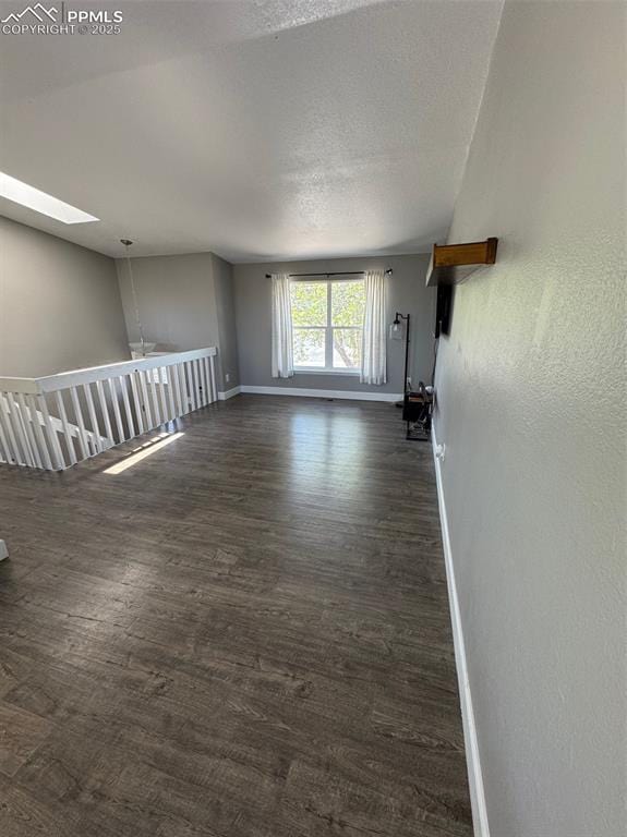 5427 Alteza Dr, Colorado Springs, CO 80917 - unfurnished living room with baseboards, a skylight, and dark wood-type flooring